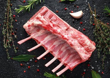raw fresh rack of lamb with green herbs. clipart
