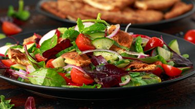 Geleneksel soğanlı salata Pide kruton, salatalık, domates, kırmızı soğan, sebze karışımı ve otlar ile bir plaka üzerinde