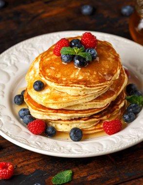 Ev yapımı Amerikan krep taze yaban mersini, ahududu ve bal ile. Sağlıklı sabah kahvaltı. rustik tarzı