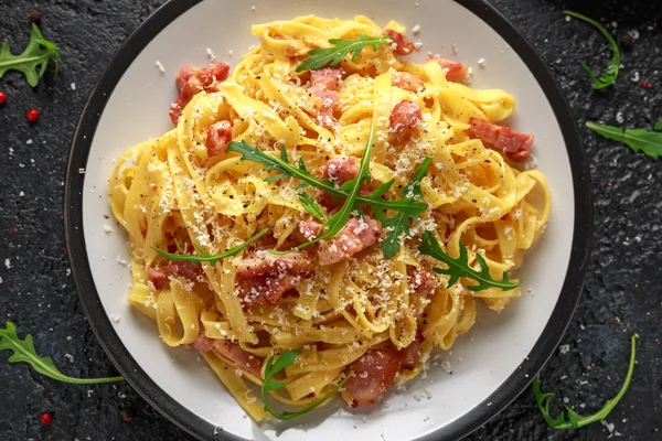 Класична карбонара паста, спагетті з млинцем, беконом, яйцем, пармезановим сиром та зеленою рушею . — стокове фото