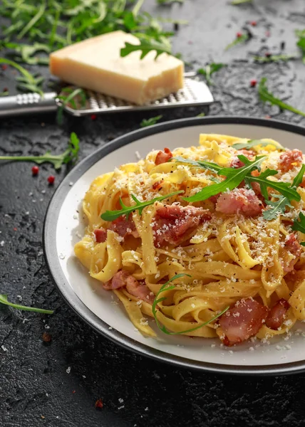 Классическая паста из карбонары, спагетти с панчеттой, беконом, яйцом, сыром пармезан и зеленой рукколой . — стоковое фото