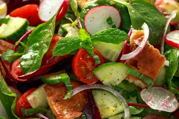 Insalata di ingrasso tradizionale su un piatto con crostini di pita, cetriolo, pomodoro, cipolla rossa, mix di verdure ed erbe aromatiche — Foto Stock