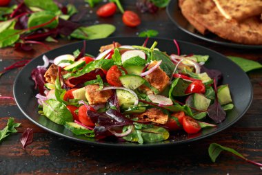 Geleneksel soğanlı salata Pide kruton, salatalık, domates, kırmızı soğan, sebze karışımı ve otlar ile bir plaka üzerinde