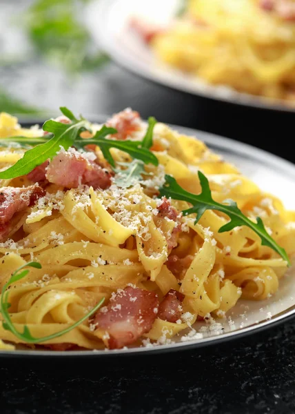 Pasta Carbonara clásica, espaguetis con panceta, tocino, huevo, queso parmesano y rúcula verde . — Foto de Stock