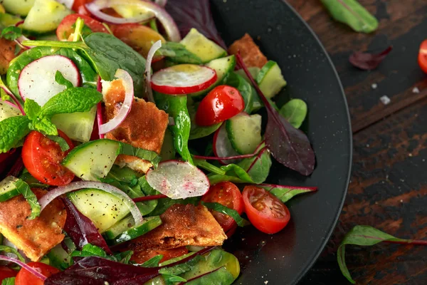 Традиційний салат на тарілці з грінками піта, огірком, помідорами, червоною цибулею, овочами та травами — стокове фото
