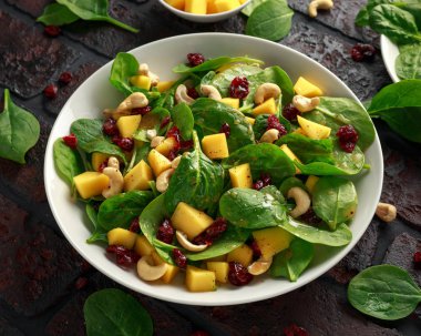 Kurutulmuş cranberries ve fındık ile Mango ıspanak salatası. sağlıklı gıda.
