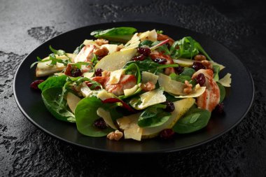 Armut, kaşar peyniri, kızılcık ve ceviz tavuk salatası. sağlıklı gıda. siyah taş zemin