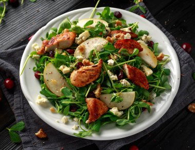 Armut, mavi peynir, kızılcık ve ceviz tavuk salatası. kavram sağlıklı gıda. siyah arka plan