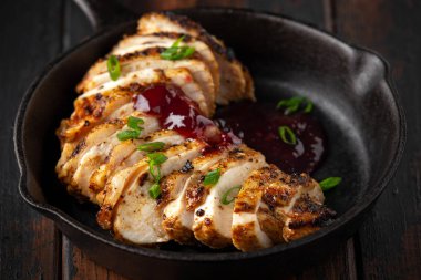 Mini dökme demir tavada Kızılcık soslu ızgara dilimlenmiş tavuk göğsü