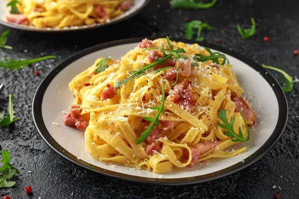 Pasta Carbonara clásica, espaguetis con panceta, tocino, huevo, queso parmesano y rúcula verde . — Foto de Stock