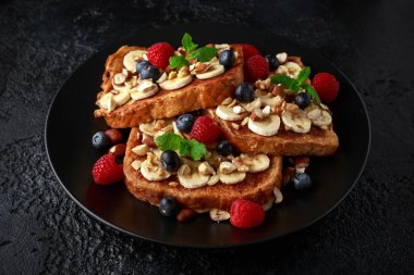 Tarçınlı tost böğürtlen, ahududu, muz, fındık, fındık ve bal ile Fransız.