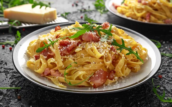 Pasta Carbonara clásica, espaguetis con panceta, tocino, huevo, queso parmesano y rúcula verde . — Foto de Stock