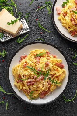 Klasik Carbonara makarna, spagetti pancetta, pastırma, yumurta, parmesan peyniri ve yeşil roka ile.