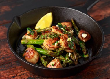 Dökme demir tavada hizmet sarımsak ve maydanoz tereyağında kızarmış deniz tarağı