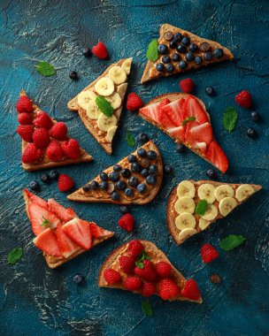 Fıstık ezmesi sandviç taze çilek, yaban mersini, ahududu ve muz yemek tost ile.