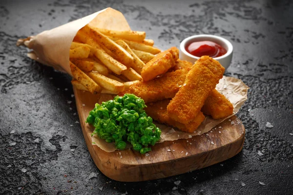 Fiskpinnar, mosade ärtor och chips frites. Traditionella brittiska snabbmat — Stockfoto