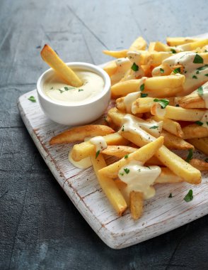 Ev yapımı pişmiş patates kızartması Beyaz ahşap tahta üzerinde peynir sos ile