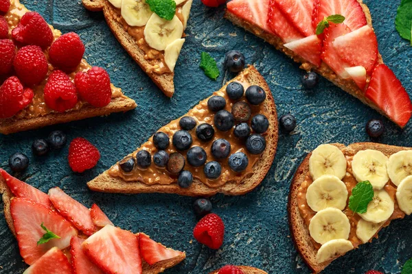 Panini al burro d'arachidi con fragola fresca, mirtillo, lampone e banana pane tostato integrale . — Foto Stock