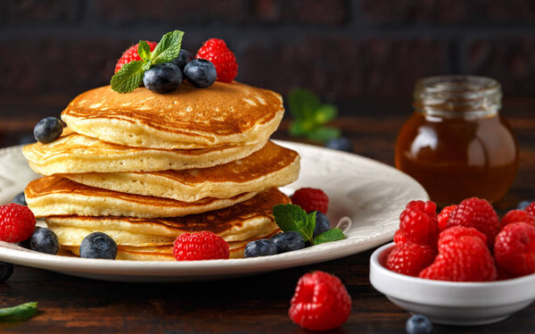 Домашние американские черничные блинчики с малиной. Здоровый утренний завтрак. деревенский стиль
.