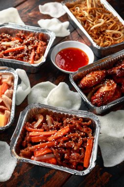 Çin yemeği paket servisi olan restoran. Gevrek parçalanmış sığır eti, tatlı ve ekşi tavuk kanatları, fasulye filizi, ananas, acı biber sosu ve karides kraker ile erişte yumurta