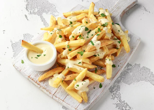 Batata caseira batatas fritas com molho de queijo na tábua de madeira branca — Fotografia de Stock