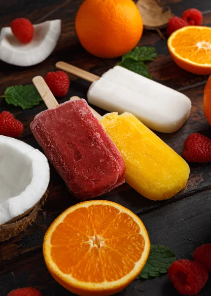 Coco casero, naranja, paletas de frambuesa, helado, sobre mesa de madera. Comida de verano . —  Fotos de Stock