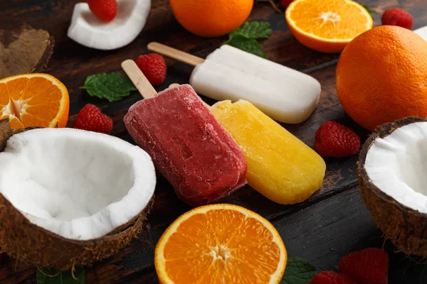 Coco casero, naranja, paletas de frambuesa, helado, sobre mesa de madera. Comida de verano . —  Fotos de Stock