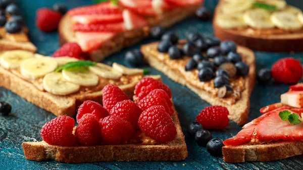 신선한 딸기, 블루베리, 딸기, 바나나 전체 식사 토스트로 땅콩 버터 샌드위치. — 스톡 사진