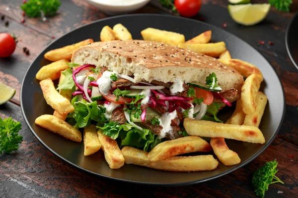 Kebab Doner, carne de cordeiro frito com legumes, batatas fritas e molho de alho em pão turco — Fotografia de Stock