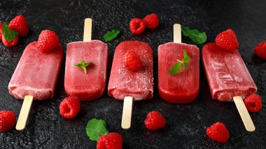 Ev yapımı ahududu çubuklu dondurmayı, Buz lolly rustik siyah arka plan üzerine