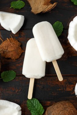 Ev yapımı Hindistan cevizi çubuklu dondurmayı Buz lolly, ahşap masa üzerinde. Yaz gıda.