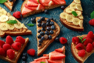 Fıstık ezmesi sandviç taze çilek, yaban mersini, ahududu ve muz yemek tost ile.
