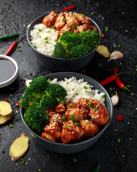 Teriyaki chicken, steamed broccoli and basmati rice served in two Asian clay bowls