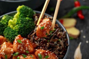 Teriyaki tavuk, haşlanmış brokoli ve yabani pirinç iki Asya kil kase içinde servis.