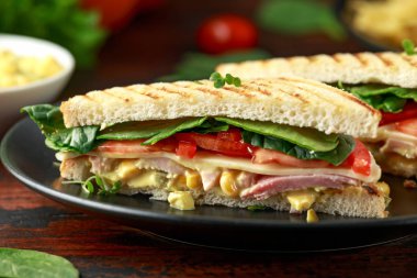 Jambon, peynir, domates, ıspanak, Mısır, mayonez, hardal, turşusu, kızarmış ekmek ve patates cipsi ile sandviç.