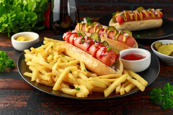 Salsicha frankfurter cachorros-quentes com batatas fritas francesas, pepinos de corte crinkle chips, ketchup e mostarda. fast food — Fotografia de Stock