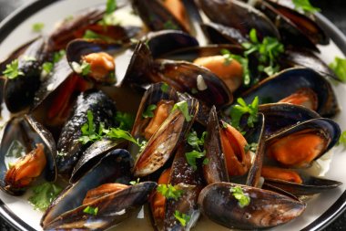 Beyaz şarap, sarımsak, limon ve otlar bir tabak, patates kızartması ile Midye. rustick arka plan. Deniz ürünleri.