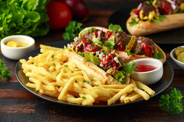 Almôndegas cachorros-quentes com batatas fritas, batatas fritas, pepinos cortados, ketchup e mostarda. fast food — Fotografia de Stock