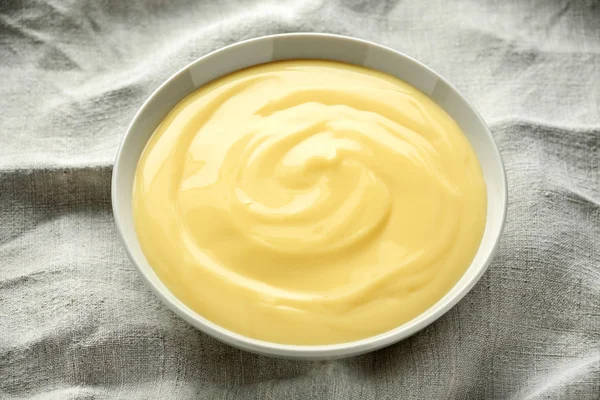 Bowl of vanilla custard on rustic background — Stock Photo, Image