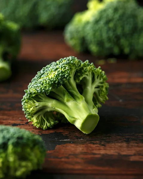 Gesunder grüner roher Brokkoli auf rustikalem Holztisch. — Stockfoto