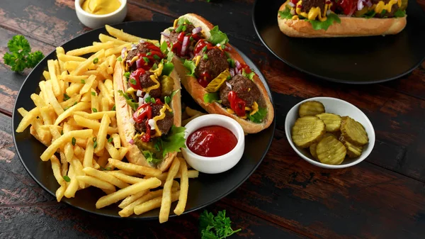Almôndegas cachorros-quentes com batatas fritas, batatas fritas, pepinos cortados, ketchup e mostarda. fast food — Fotografia de Stock