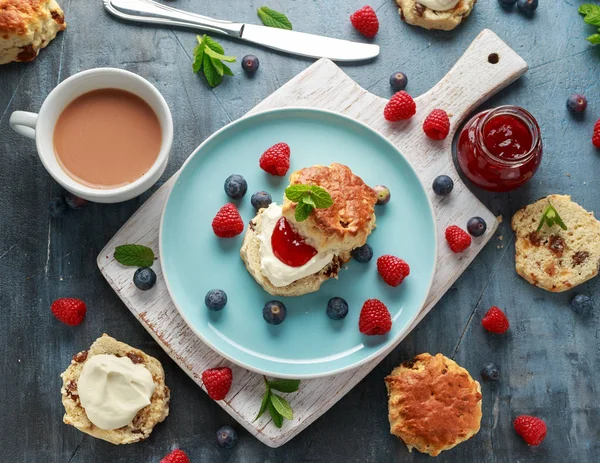 Klassiska scones med clotted Cream, jordgubbar sylt, engelskt te och annan frukt — Stockfoto
