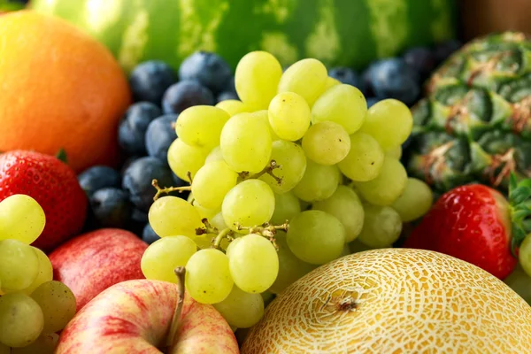 Variété de fruits frais et de baies sur fond sombre : cantaloup, melon, pastèque, myrtille, oranges, pomme, fraise, ananas, mangue, raisin et kiwi . — Photo