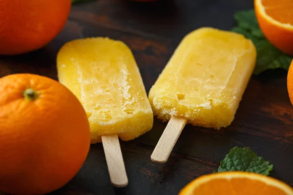 Домашнее оранжевое мороженое, ледяной леденец, на деревянном столе. Летняя еда . — стоковое фото