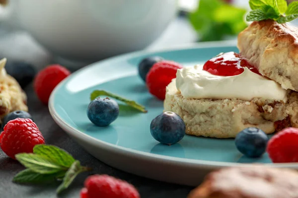 Bollos clásicos con crema coagulada, mermelada de fresas, té inglés y otras frutas —  Fotos de Stock