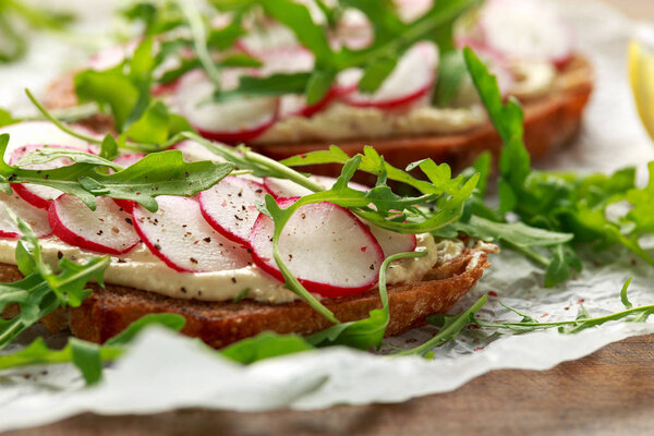 Тост из теста хумуса с красноватой и дикой ракетой. Здоровое веганское питание
