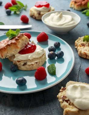 Pıhtılaşmış krema, çilek reçeli ve diğer meyve ile Klasik İngiliz çörekler