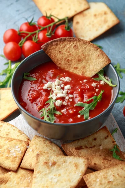 Grilled corn tortilla with sea salt flakes, spicy tomato salsa sauce and feta cheese