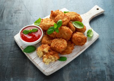 Kızarmış Mac, makarna ve peynir ısırıkları, Beyaz ahşap tahta üzerinde ketçap soslu ekmek kırıntıları
