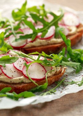 Humus ekşi maya tost kırmızımsı ve yabani roket ile. Sağlıklı vegan gıda
